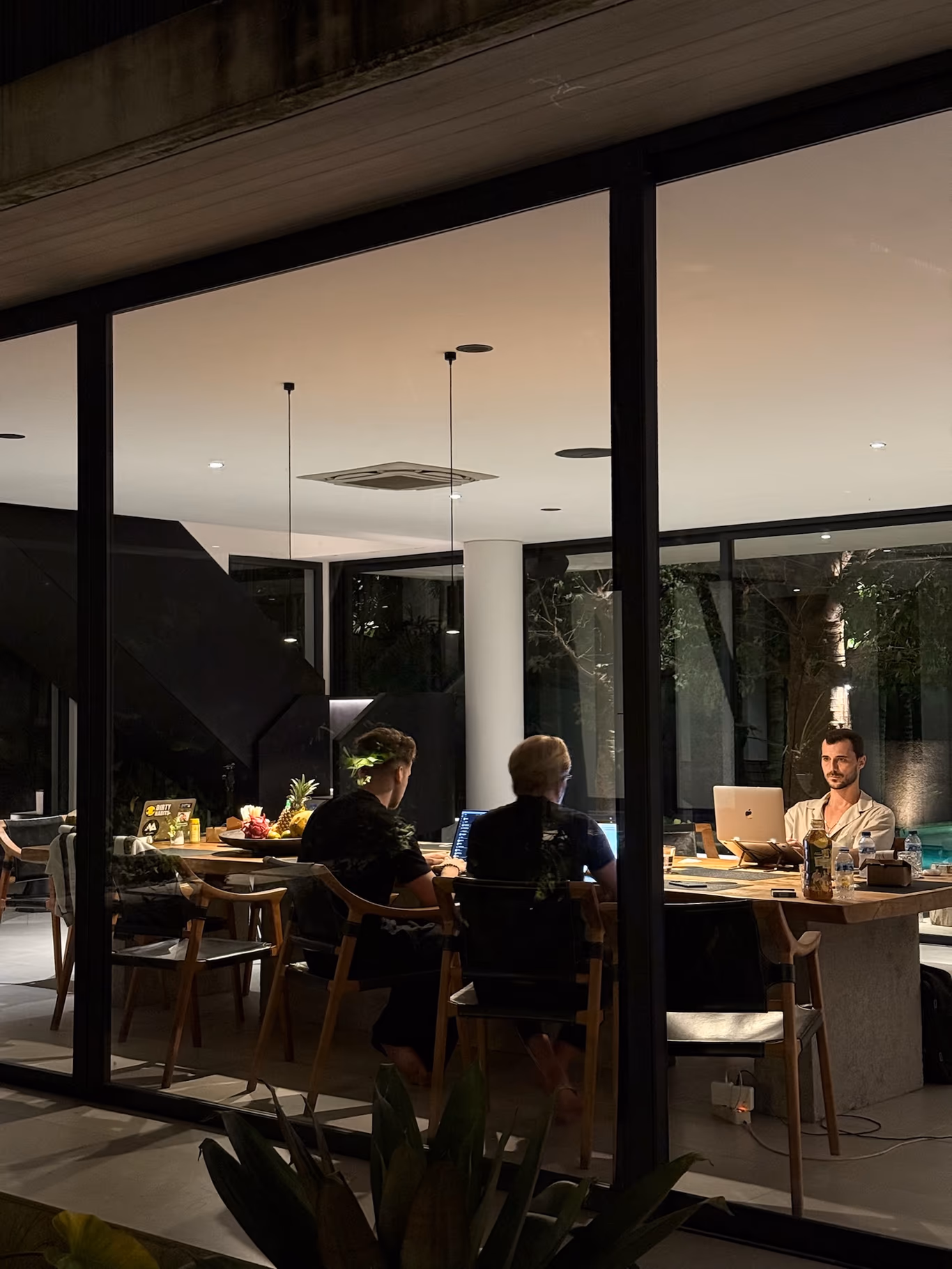 Founders along a long table in a modern room at night — a community that actually gathers