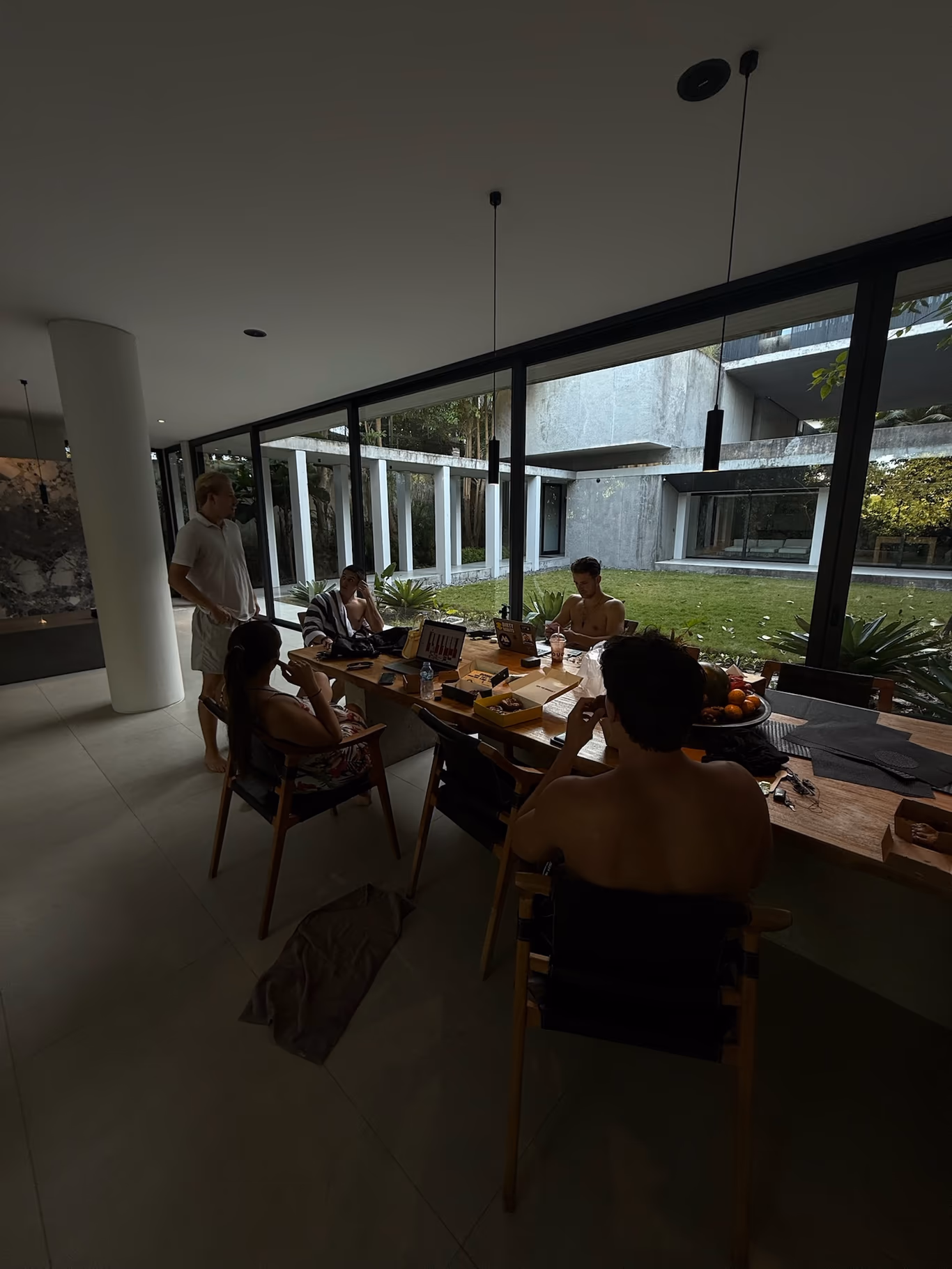 Founders working at a table by a wall of windows during a daytime mastermind session